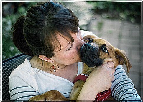 woman kissing a dog